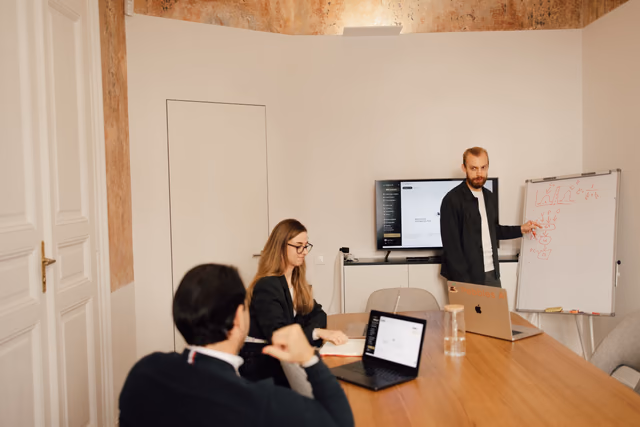 A colleague presenting at a whiteboard to the team