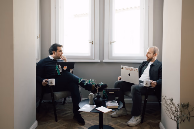 Two colleagues talking by the office window