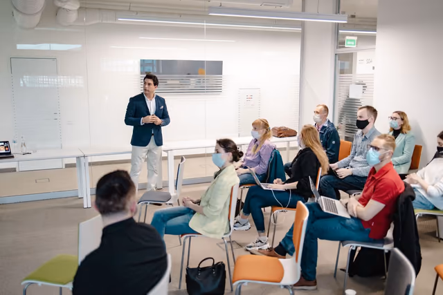 Emin leading a workshop for a seated group